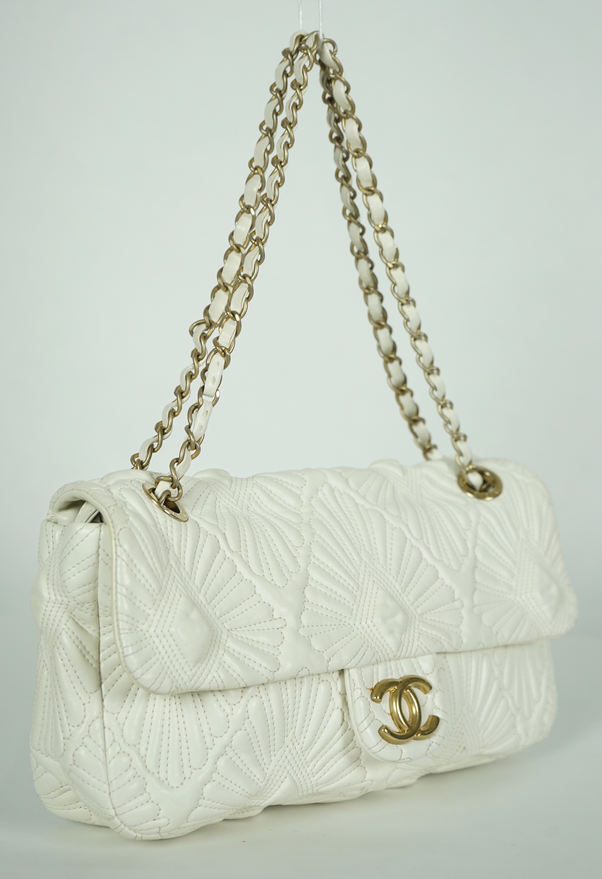 A white quilted Chanel shoulder bag, with maker’s dust bag, width 30cm, height 17cm, overall height 37cmm depth 7cm, Please note this lot attracts an additional import tax of 20% on the hammer price